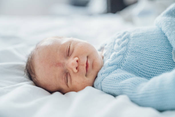 Baby boy on bed stock photo