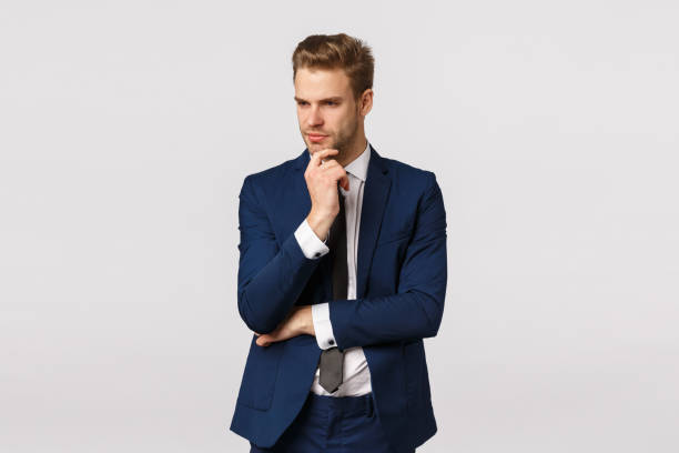 istock Thoughtful smart and focused young blond bearded man in formal classic suit, having deep thought, touching chin look away, thinking about solution, make plan, brainstorm during meeting 1207259729