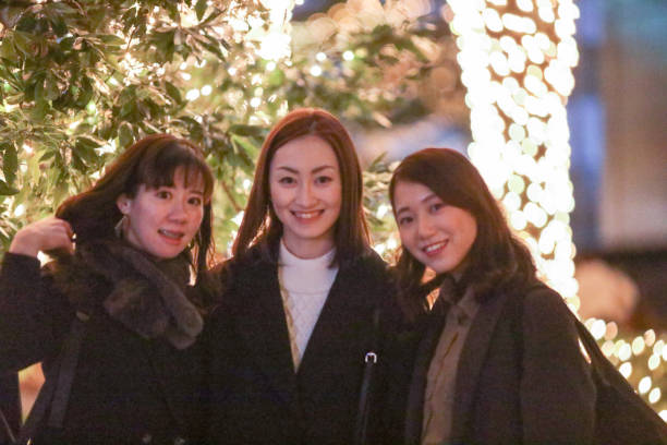 istock Young beautiful women smiling at Christmas illuminations 1207261017