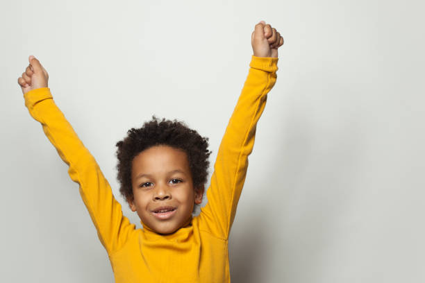 istock Happy black kid little boy with hands up on white background 1207261579