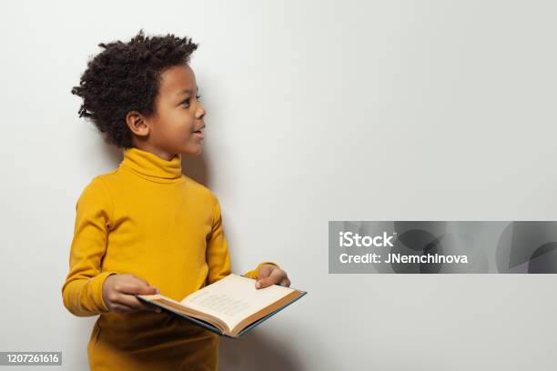 Curious Black Child Boy Reading A Book On White Background Stock Photo - Download Image Now