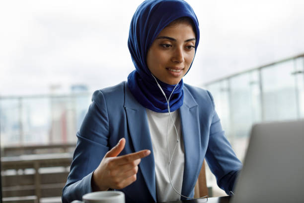 Young woman with headphones working on laptop Young woman with headphones working on laptop hijab photos stock pictures, royalty-free photos & images