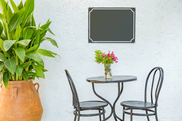 Empty street sign with chair, table and vase.