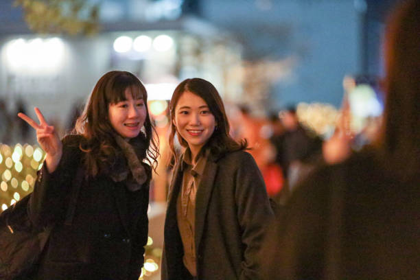 istock Young beautiful women  posing in Christmas illuminations 1207263391