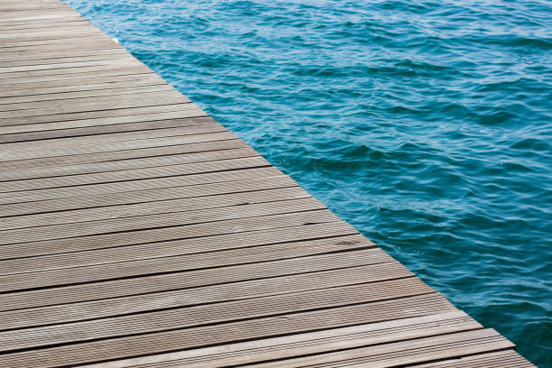 istock wooden deck diagonal surface unfocused water background sea waterfront simple wallpaper pattern with empty copy space for text or inscription 1207263433