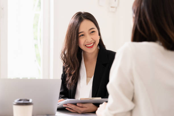 A young attractive asian woman is interviewing for a job. Her interviewers are diverse. Human resources manager conducting job interview with applicants in office A young attractive asian woman is interviewing for a job. Her interviewers are diverse. Human resources manager conducting job interview with applicants in office asian and indian ethnicities stock pictures, royalty-free photos & images