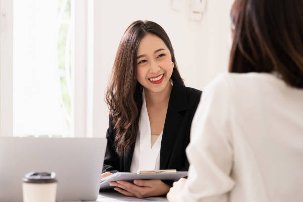 a young attractive asian woman is interviewing for a job. her interviewers are diverse. human resources manager conducting job interview with applicants in office - human resources interview talking people imagens e fotografias de stock