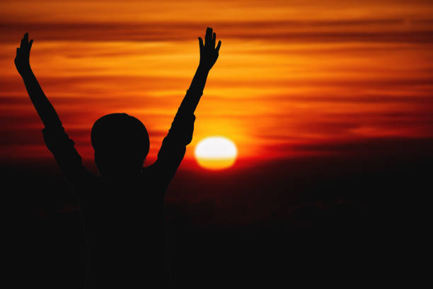 istock Woman enjoying sunset with arms wide open. 1207267015