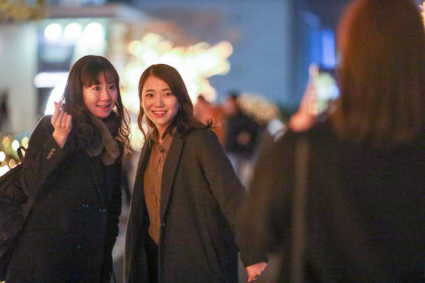istock Young beautiful women  posing in Christmas illuminations 1207268032