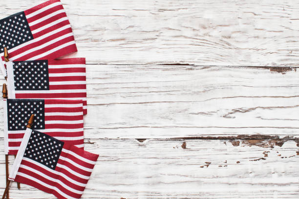 istock American Flags for the 4th of July Celebration against a White Rustic Background 1207268106