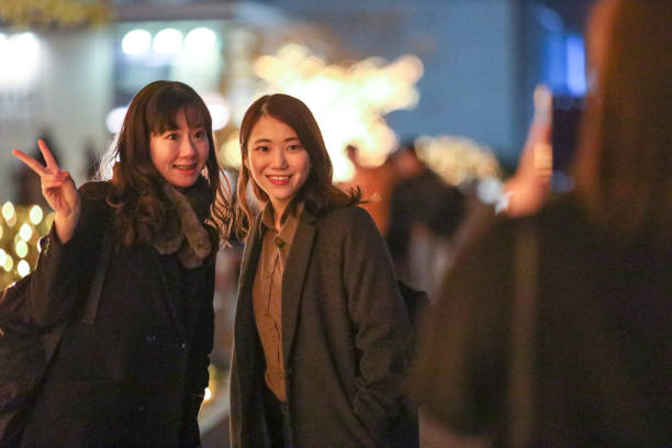 istock Young beautiful women  posing in Christmas illuminations 1207268149
