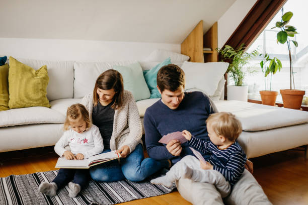 istock Mother reading with daughter while dad plays cards with son 1207268187