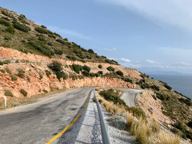 istock Aerial view over mountain road next to sea 1207268842