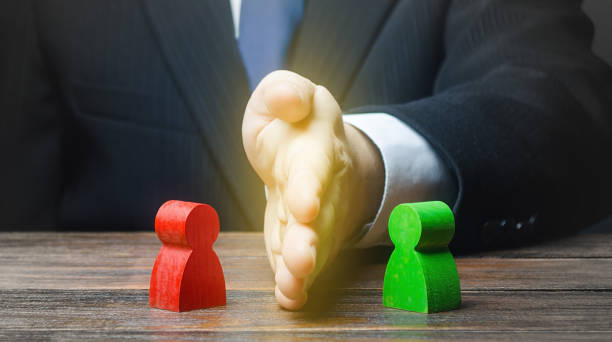istock Man puts his hand between conflicting persons. Avoidance violence, preventing conflict escalation. Stop fight, ceasefire. Find a compromise. Lawsuit trial. Witnesses protection. Mediator services. 1207268952
