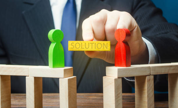 istock Man offers a solution to end conflict. Compromise dispute resolution. Build bridges improve relationships. Communication mediation between conflicting parties. escape escalations of conflicts. Win-win 1207268970