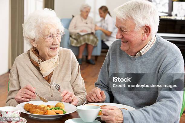 Smiling Senior Couple Eating Meal In Care Home Stock Photo - Download Image Now - Senior Adult, Eating, Food