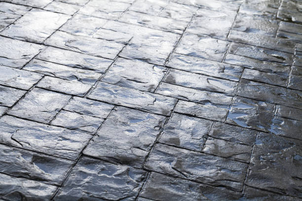 istock Shiny wet gray cobblestone road pavement 1207271041
