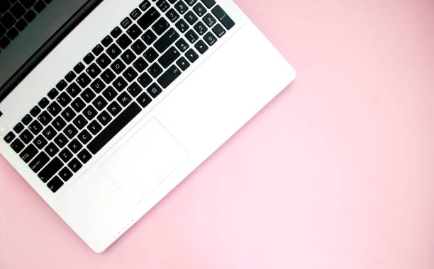 istock Black-white laptop keyboard on a pink background. Copy space. Top view. Computer work. Flat lay 1207271211