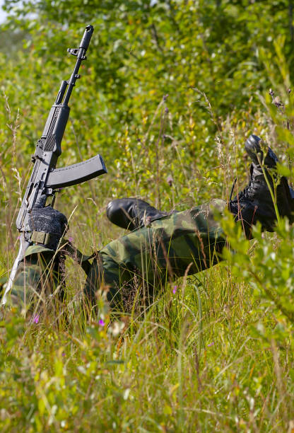 istock Two people playing airsoft hid in ambush behind fence 1207271218