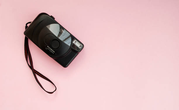 istock Black film camera on a pink background. Flat lay. Copy space. Top view 1207271289