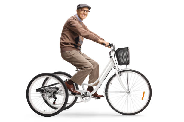 Cheerful elderly gentleman riding a tricycle and looking at camera