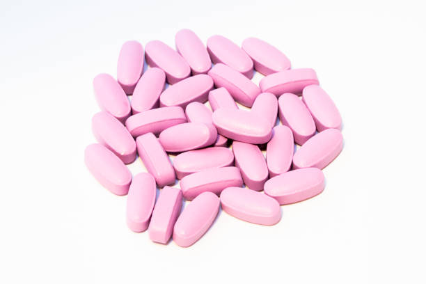 istock Pink vitamin pills isolated on white background 1207271842