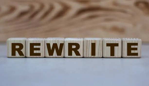 Photo of concept word rewrite on cubes on a beautiful wooden background