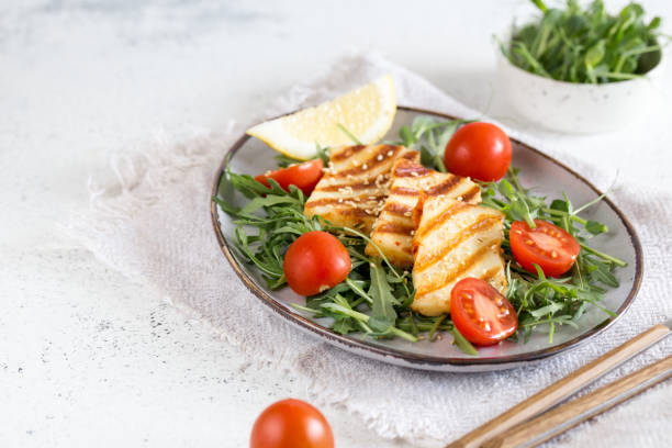 fresh salad with grilled halumi cheese, cherry tomatoes and arugula. copy space stock photo