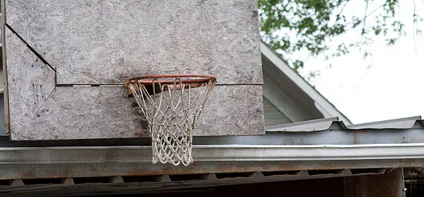 A makeshift basketball hoop on the roof of a carport.