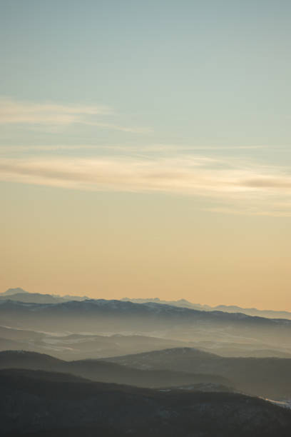 istock Beautiful view of the mountain range partially covered with snow just before sunset. Partly orange sunset sky 1207274733