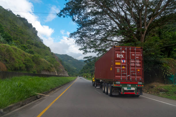 Container truck on road with trees and mountain on a sunny day. Valle del Cauca. Colombia . November 39, 2019