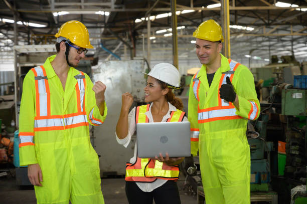 A mixed race female with laptop and two Caucasian male engineer working in factory area. A mixed race female with laptop and two Caucasian male engineer working in factory area. trainee training computer designer stock pictures, royalty-free photos & images
