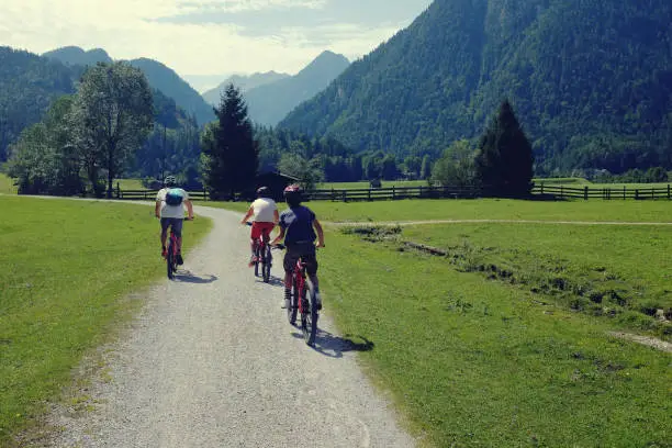 August 3, 2017 - Mondsee, Austria: father and two boys riding bikes in the countryside in Austria on their active and healthy summer vacation