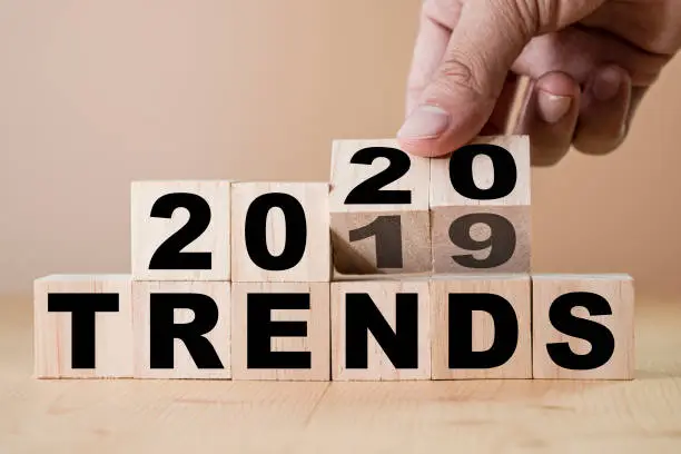 Photo of Hand flipping wooden cubes from 2019 to 2020 change trends of business technology and marketing.