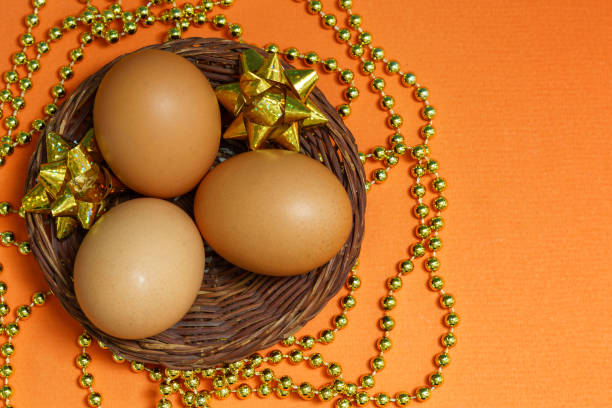 istock Eggs in a basket on a yellow background, in a gold decor 1207283203