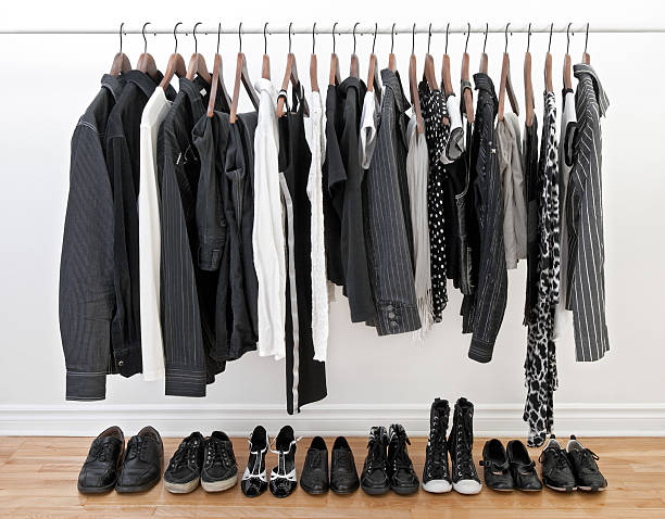 Clothes for man and woman Female and male black and white clothes on a rod and shoes on a woden floor. clothes hanger rod stock pictures, royalty-free photos & images
