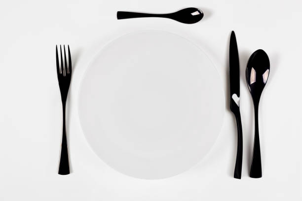 istock White ceramic round plate isolated on white. Start food concept. 1207285271