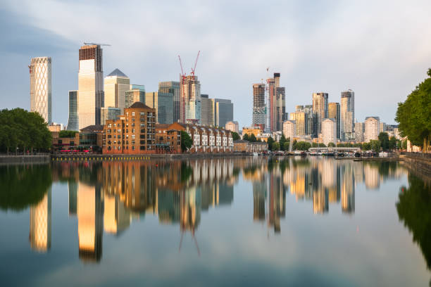london cityscape canary wharf with reflection from greenland dock at sunset - canary wharf built structure building exterior construction imagens e fotografias de stock