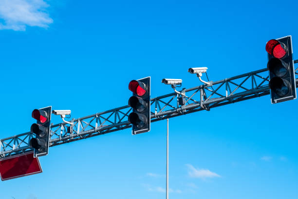 istock Red traffic lights and cameras againts blue skies 1207285558