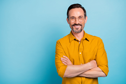 Portrait of charming mature man true boss feel content emotions wear yellow, shirt isolated over blue color background