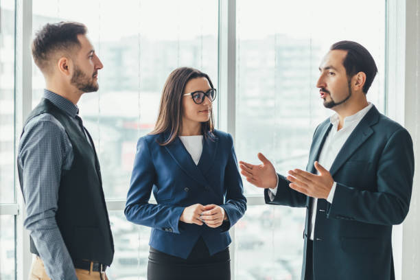 istock Three successful business people talking in office. 1207287911