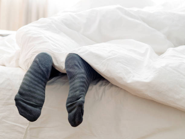 istock Lazy man sleeping with  his socks  on the bed 1207288260