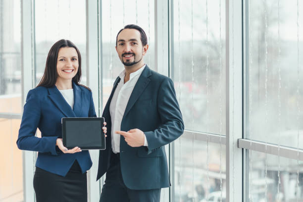 istock Respected business people showing tablet with empty screen for chart, text, or diagram, isolated on white background. 1207288527