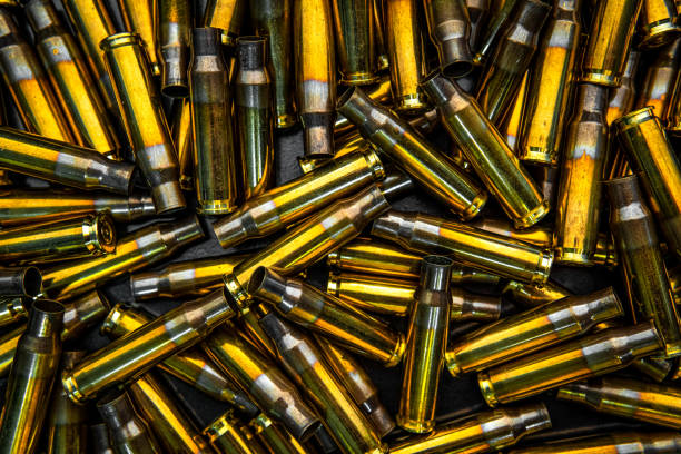 istock Background from empty cartridges for rifles and carbines. Shiny brass shells scattered on the surface. 1207290429