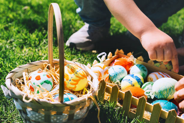 istock Colorful Easter eggs in basket. Children gathering painted decoration eggs in spring park. Kids hunt for egg outdoors. 1207290699