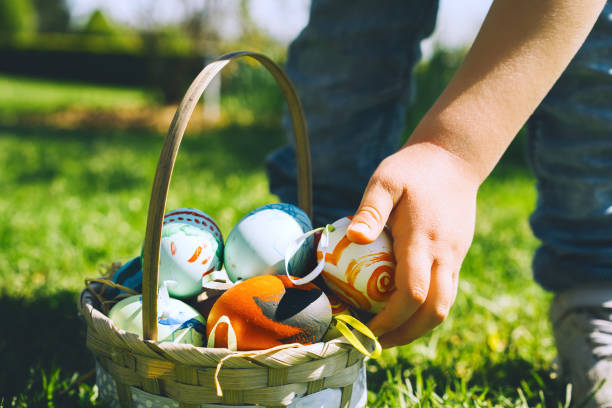 istock Colorful Easter eggs in basket. Children gathering painted decoration eggs in spring park. Kids hunt for egg outdoors. 1207290721