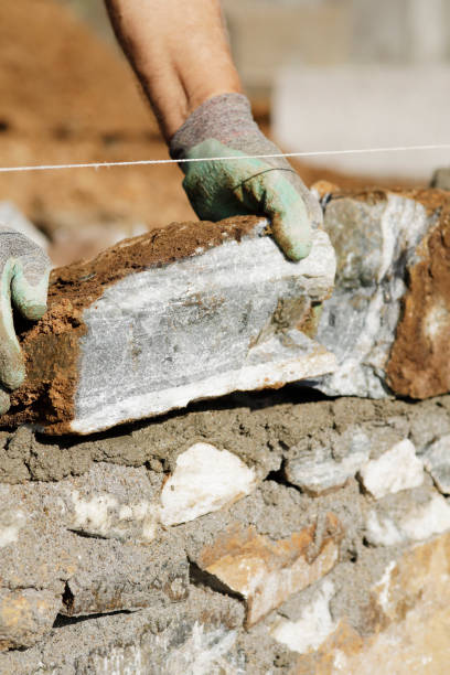 istock Close-up of construction worker builds stone wall 1207291487