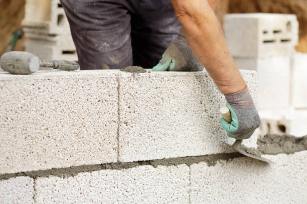 istock Close-up of construction worker builds brick wall 1207292699
