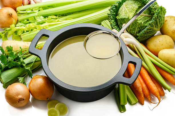 istock Vegetables broth in a cooking pan on white background 1207293030