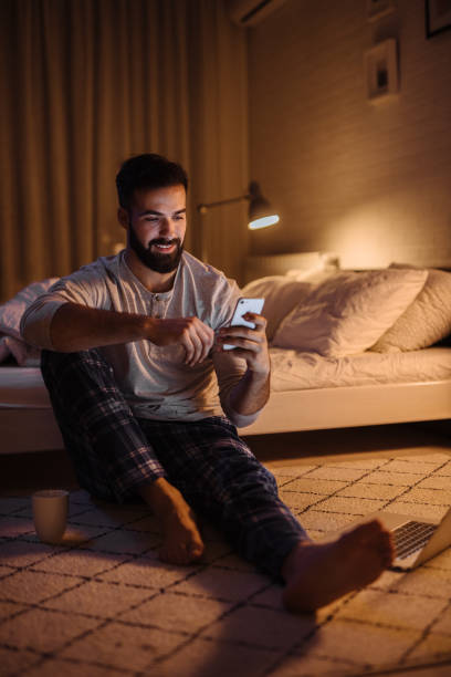 istock Handsome bearded man using smartphone in his bedroom at night 1207294690